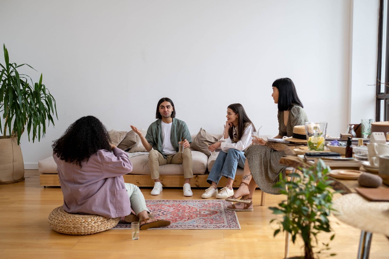 A small group sitting together in a living room, mid-conversation — illustrative demo image